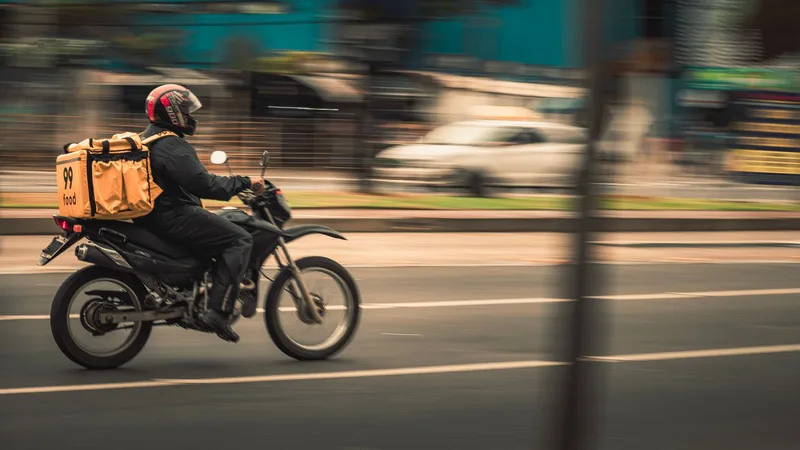 Motorcycle courier rider delivering packages through city streets in Indonesia