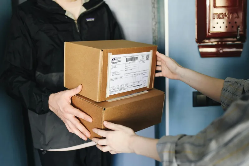 Cash on delivery payment being exchanged at door with parcel in UAE ecommerce delivery